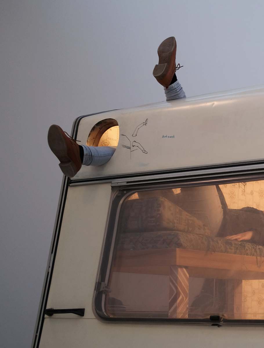 mobile home person laying on bed inside vehicle motorhome